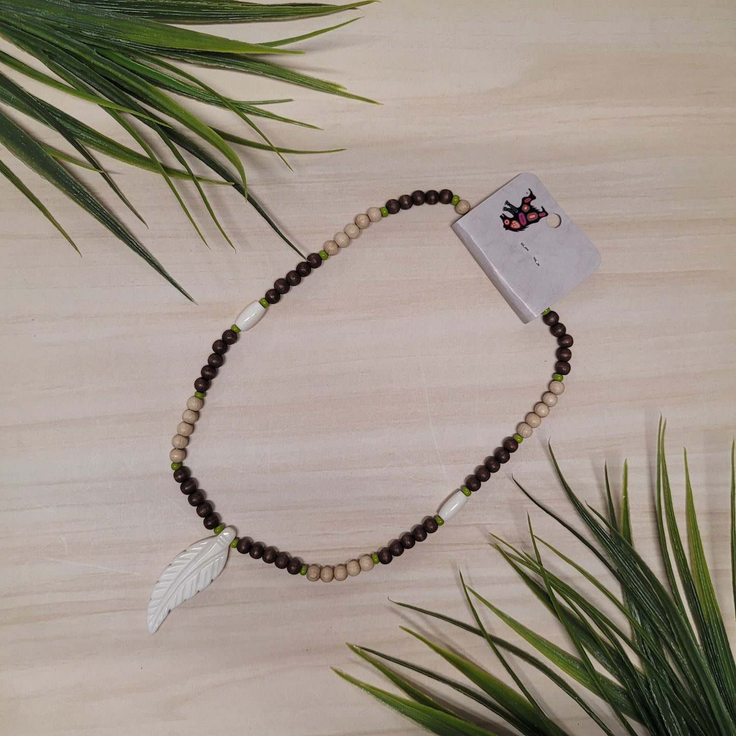Collier de billes de bois brunes et beige avec pendentif en os
