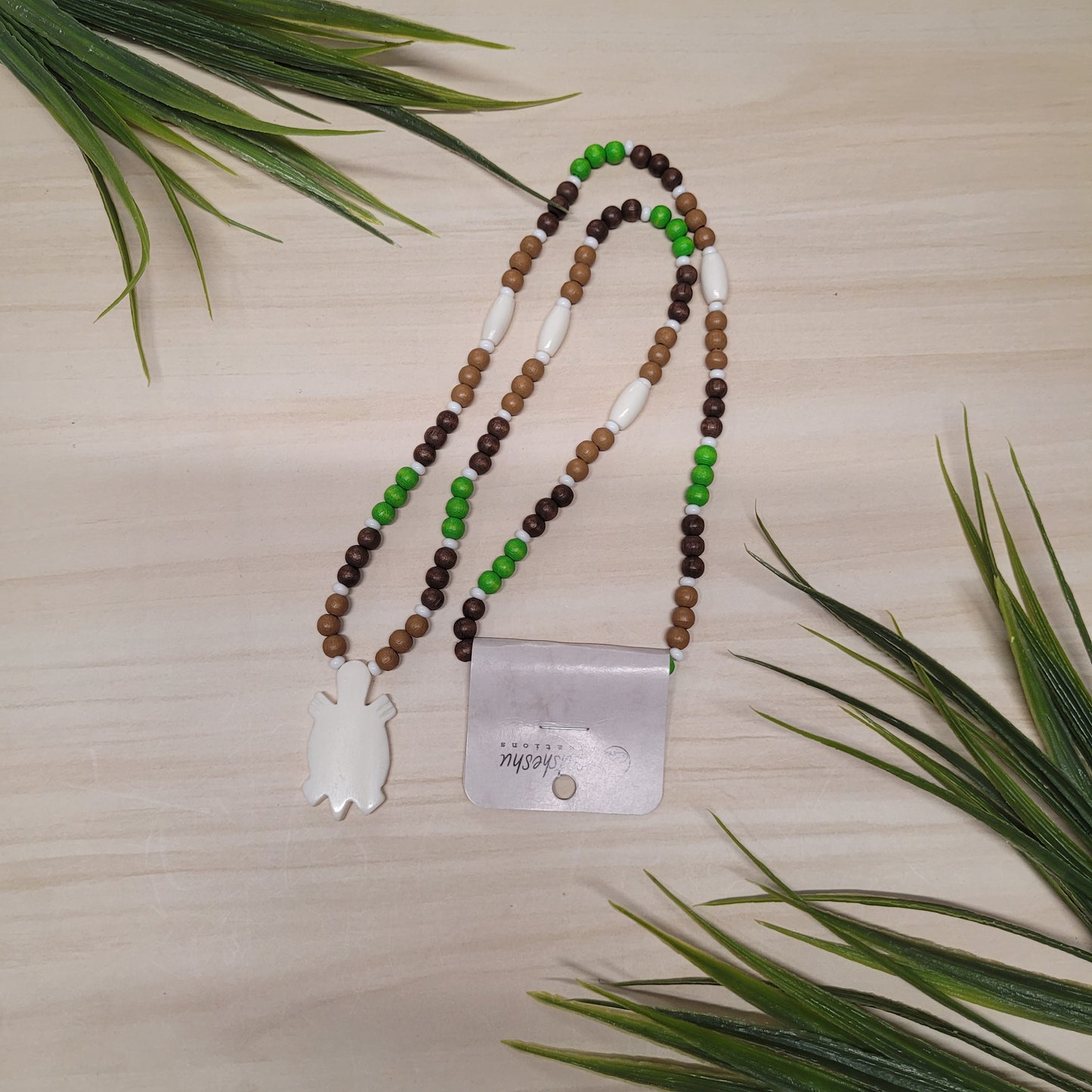 Collier de billes de bois vertes, brunes et marron avec pendentif en os