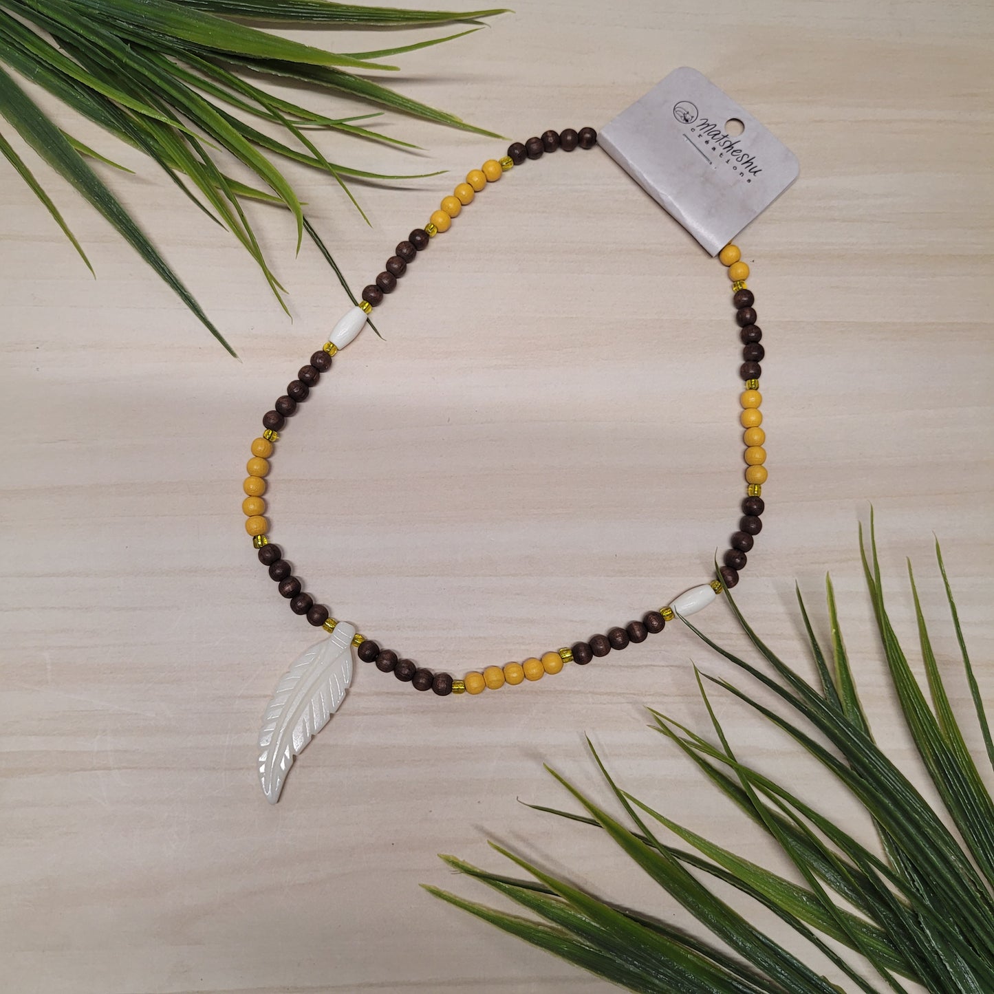 Collier de billes de bois jaunes et brunes avec pendentif en os